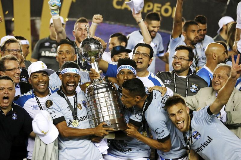 epa06358566 Leonardo Moura (C-L), Bruno Cortez (C) and Cicero (C-R) of Gremio celebrate with the trophy after winning the Libertadores Cup final soccer match between Lanus of Argentina and Gremio of Brazil at the Ciudad de Lanus Stadium in Buenos Aires, Argentina, 29 November 2017.  EPA/DAVID FERNANDEZ