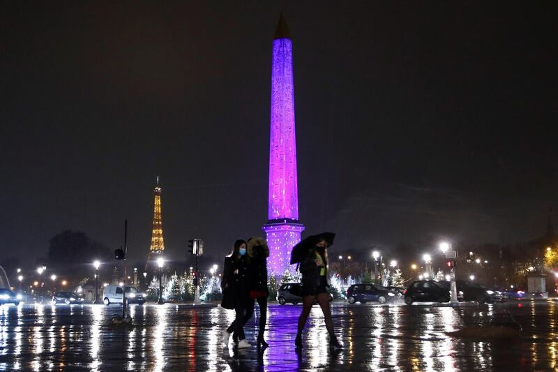 Women wearing protective face masks walk at the Place de la Concorde as Christmas trees decorate along the Champs Elysees avenue leading up to the Eiffel Tower in Paris, France December  4, 2020. REUTERS/Gonzalo Fuentes
