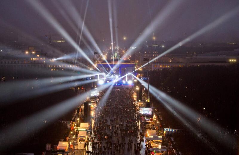 Revellers in the streets of Berlin during a light show at a stage in front of the Brandenburg Gate during the New Year's Eve party. Joerg Cartensen/EPA