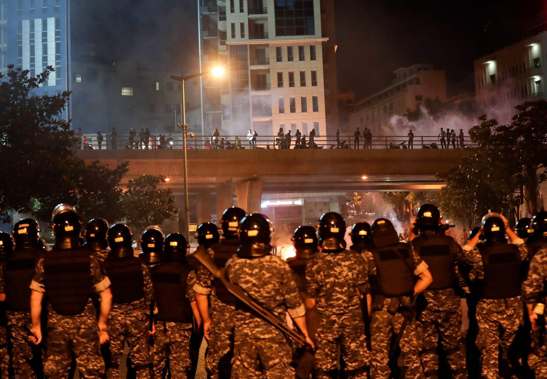 Anti-government protesters gather on the Fuad Shehab bridge, known as the Ring, as Lebanese security forces stand guard below, during a demonstration against dire economic conditions in the capital Beirut. AFP