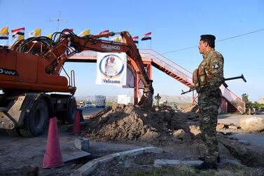 epa09044214 An Iraqi policeman stands guard as Iraqi workers perform maintenance work near the al-Tahira al-Kubra church (the Grand Immaculate Church) ahead of the Pope's visit to the church at the Assyrian town of Qaraqosh, some 13 km east of Mosul, northern Iraq, 25 February 2021 (issued 01 March 2021). Pope Francis will visit the Church of Grand Immaculate near Mosul, during his trip to Iraq from 05 to 08 March 2021. EPA/AMMAR SALIH