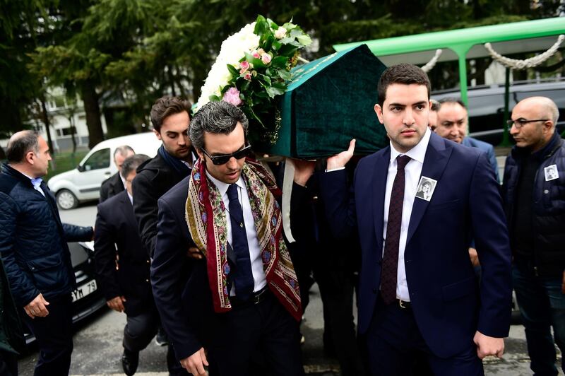 Sinan Urfali, left, the husband of Burcu Gundogar Urfali, carries his wife's coffin. AFP