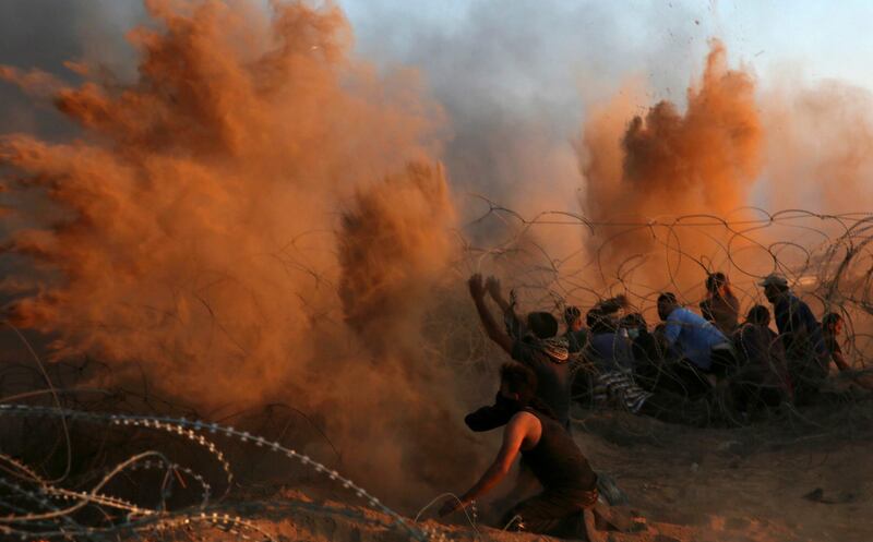 Protesters spread sand in the air while others burn tires near the fence of the Gaza Strip border with Israel during a protest east of Khan Younis, southern Gaza Strip, on Friday, October 12, 2018.  AP Photo
