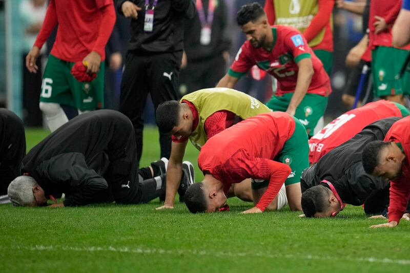 Morocco players kneel on the pitch at the end of the match. AP