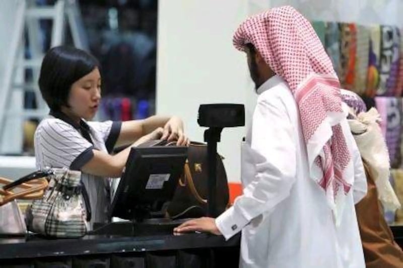 A saleswoman attends to a customer at the cash counter inside a shop at Dragon Mart in Dubai, March 2, 2011. Built in the shape of a dragon, the 1.2 km long and 150,000 sqm large mall is a trading centre with almost 3,950 shops selling mainly Chinese products ranging from office appliances to garments and daily products. Picture taken March 2, 2011. REUTERS/Jumana El Heloueh (UNITED ARAB EMIRATES - Tags: BUSINESS) *** Local Caption *** DUB03_DUBAI-_0303_11.JPG