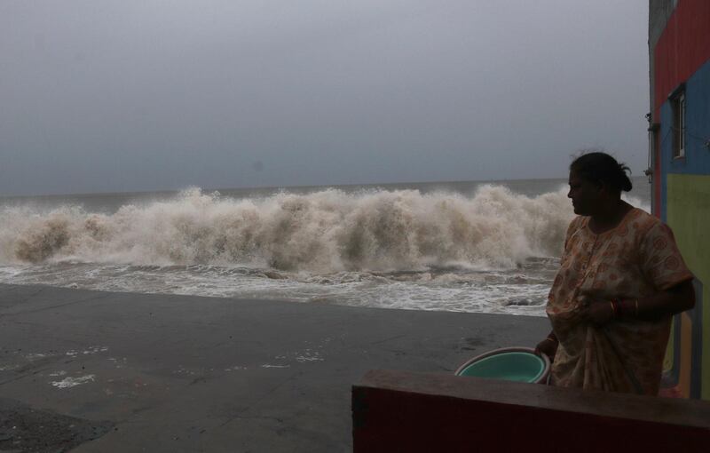 A woman watches waves splash on shores of the Arabian Sea in Mumbai, India. AP Photo