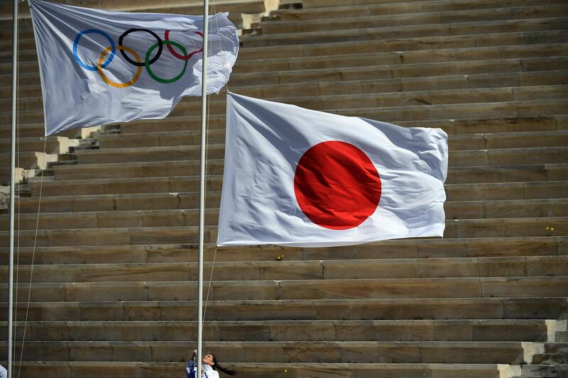 A Japan's flag is raised next to the Olympic flag. AFP