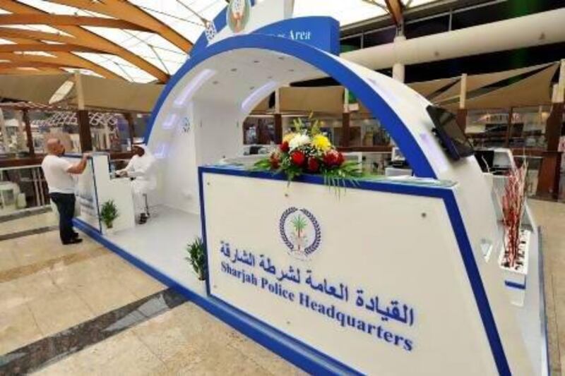 Police officer Jasim Mohammed Al Kalbani gives a visitor information about his vehicle registration at the mall station. Charles Crowell for The National