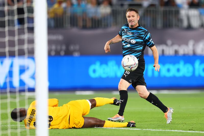 Robbie Keane, manager of Team World XI, shoots past David Harewood of Team England. Getty Images