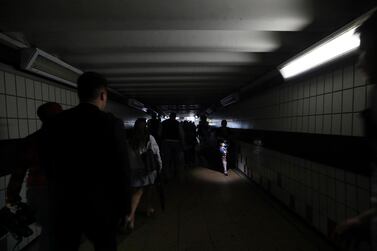 People walk in near darkness at Clapham Junction station during a power cut, in London, Friday, Aug. 9, 2019. London and large chunk of the U.K. were hit with a power cut Friday afternoon that disrupted train travel and snarled rush-hour traffic.U.K. Power Networks, which owns and maintains electricity cables in London and southern England, said a network failure at power supplier National Grid was affecting its customers. (Yui Mok/PA via AP)