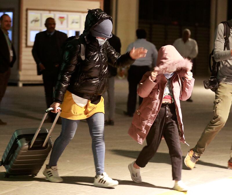 Iraqis covers their faces as they arrive at the airport in Baghdad. AFP