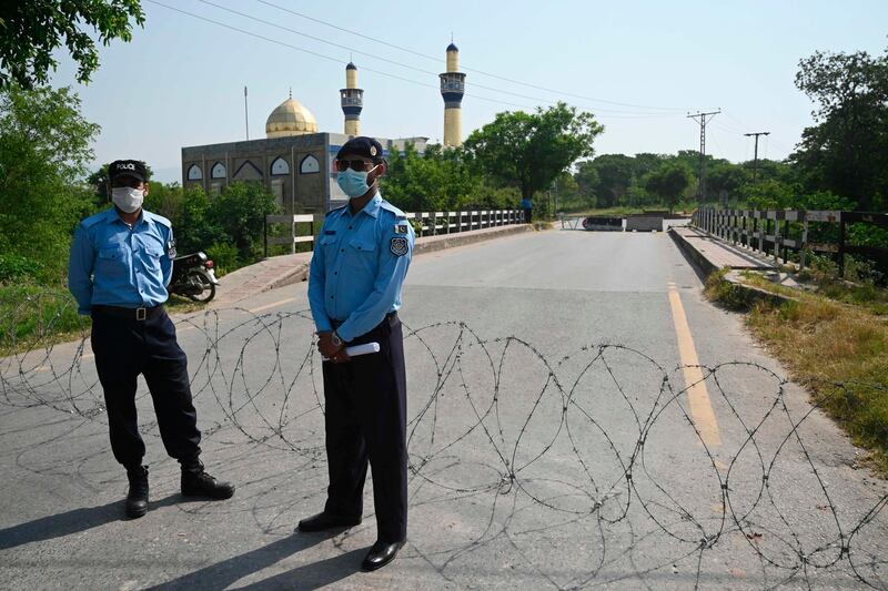 Police officers wearing facemasks stand guard next to a street sealed by the authorities at I-8 residential sector in Islamabad as cases of COVID-19 coronavirus continue to rise in Pakistan. AFP