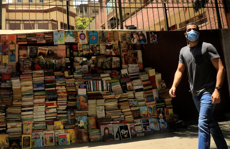 A man wearing a protective face mask walks past a bookstand on street in central Cairo. Reuters