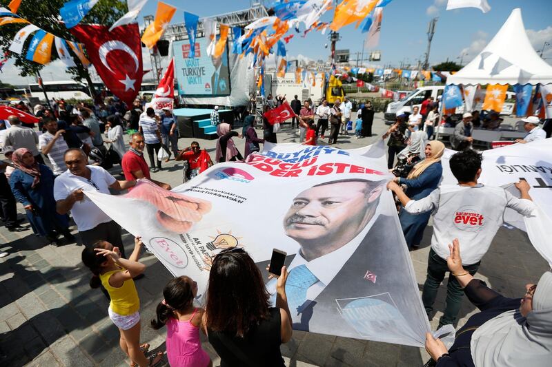 In this photo taken on Wednesday, June 20, 2018, people wave a banner with a picture of Turkey's President Recep Tayyip Erdogan, during a gathering of supporters of his ruling Justice and Development Party (AKP) in Istanbul. The most powerful and polarizing leader in Turkish history is standing for re-election in a presidential vote on Sunday that could cement Turkey's switch from a parliamentary to a presidential system, which was narrowly approved in a referendum last year.AP Photo/Lefteris Pitarakis)