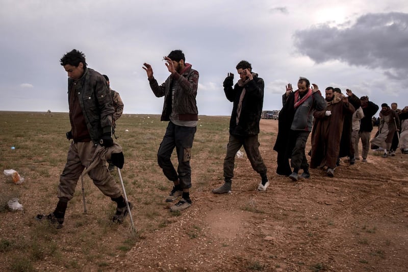 Men suspected of belonging to ISIS walk to be screened by Syrian Democratic Forces outside Baghouz, Syria 28 February 2019. Campbell MacDiarmid