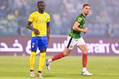 Al Ettifaq's Jordan Henderson runs past Al Nassr forward Sadio Mane during their Saudi Pro League match in Dammam. AFP