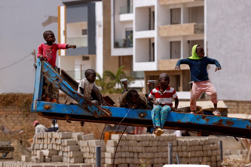 Children play on a lorry trailer while watching car racing on the runway of the old airport in Dakar, Senegal. Reuters