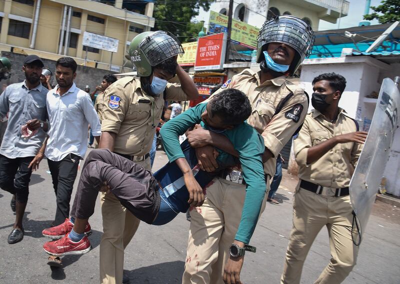 Policemen carry a wounded protester in Secunderabad. Reuters