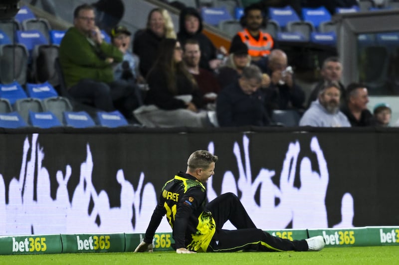 David Warner of Australia recovers after landing awkwardly in the field. EPA 