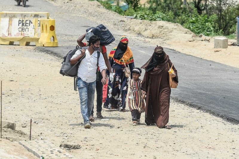 Migrant people walk towards the ferry terminal to go back to their home places ahead of the Eid-Al-Fitr festival which marks the end of the Islamic holy month of Ramadan, during a government-imposed lockdown as a preventive measure against the COVID-19 coronavirus, in Munshiganj on the outskirts of Dhaka. AFP