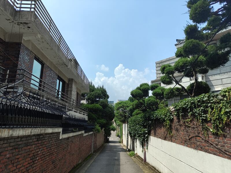 Houses and trees line a residential street in Seoul.