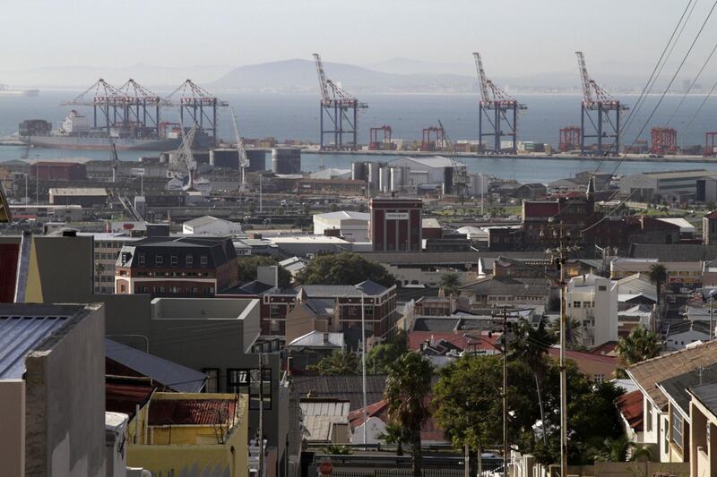 The residential district of Woodstock overlooks gantry cranes on the harbourside in the commercial port area of Cape Town, South Africa, on Wednesday, April 24, 2013. South Africa's gross domestic product is forecast to expand 2.6 percent this year, compared with 2.5 percent in 2012, according to the country's central bank. Photographer: Nadine Hutton/Bloomberg