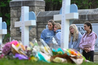 Students at a nearby school pay respects at a memorial for victims at an entry to Covenant School. AP