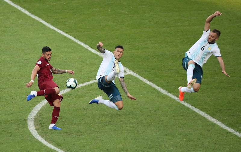 Argentina's Leandro Paredes and German Pezella attempt to block a shot from Venezuela's Junior Moreno. Reuters