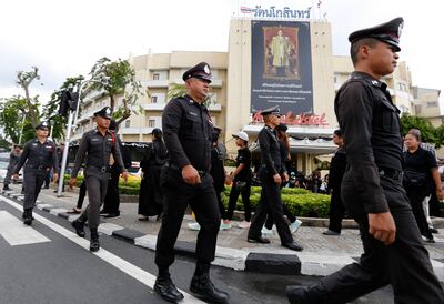 epa06285562 The police officers walk under the portrait of the late Thai King Bhumibol Adulyadej, in the area of Sanam Luang, in Bangkok, Thailand, 24 October 2017. The Royal Cremation ceremony of the late King Bhumibol Adulyadej is scheduled on 26 October 2017, and the funeral will consist of five days of rites. King Bhumibol died at the age of 88 in Siriraj hospital on 13 October 2016 after 70 years on the throne.  EPA/NARONG SANGNAK