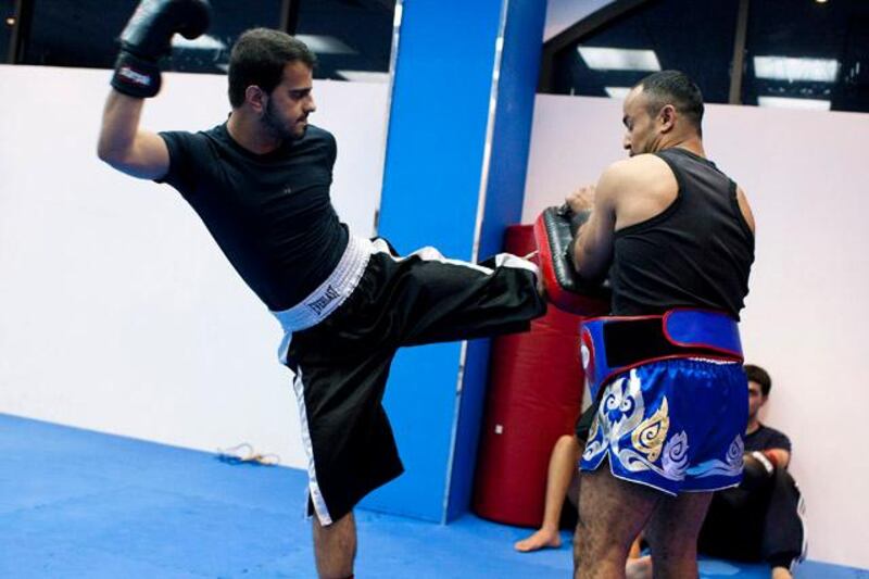 ABU DHABI, UAE - July 6, 2011-  Ahmed Al Hosani trains with his coach Juma Ben Jamma at World Gym in Abu Dhabi on Wednesday July 6, 2011.  A rare illness left Ahmed Al Hosani deaf and mute at the age of two.  All he wanted was to be like everyone else.  As a member of the Abu Dhabi Special Needs club, Ahmed has found salvation in kick-boxing, turning professional last month.  Recently he drew his first fight in Dubai and now wants to compete in the Olympics next year.  (Andrew Henderson / The National)