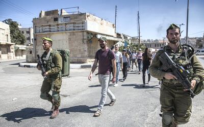 Israeli soldiers escort Ido Even-Paz and the group he is leading on the "Breaking the Silence" tour  through the divided area of the West Bank city of Hebron on September 27,2018. The Israeli army insisted to escort the group because of the large number of Jews were visiting the area for the holiday of Sukkot and they wanted to prevent any friction .(Photo by Heidi Levine for The National).