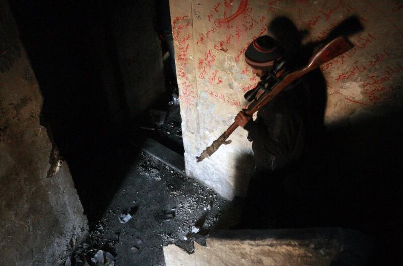 A rebel fighter carries his rifle down the stairs of a building in the northern Syrian city of Aleppo on February 9, 2014. The civil war in Syria has claimed more than 136,000 lives and driven millions from their homes, many of whom have fled to neighbouring Turkey, Lebanon, Jordan and Iraq, raising fears of a regional spillover of the conflict. Mohamed Abdel Rahman / AFP photo