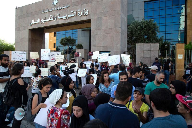 Lebanese students from different private universities along with their parents carry placards during a protest in front the Ministry of Education in Beirut, Lebanon.  EPA
