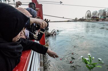 Iraqi women cast flowers into the Tigris river in remembrance for the victims of the capsized ferry in the northern Iraqi city of Mosul. AFP