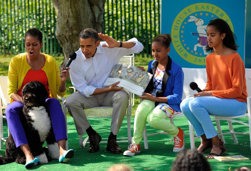 Barack Obama reads from the children's book 'Where the Wild Things Are' along with Michelle Obama, daughters Sasha and Malia, and their dog Bo, during the White House Easter Egg Roll in April 2012. EPA