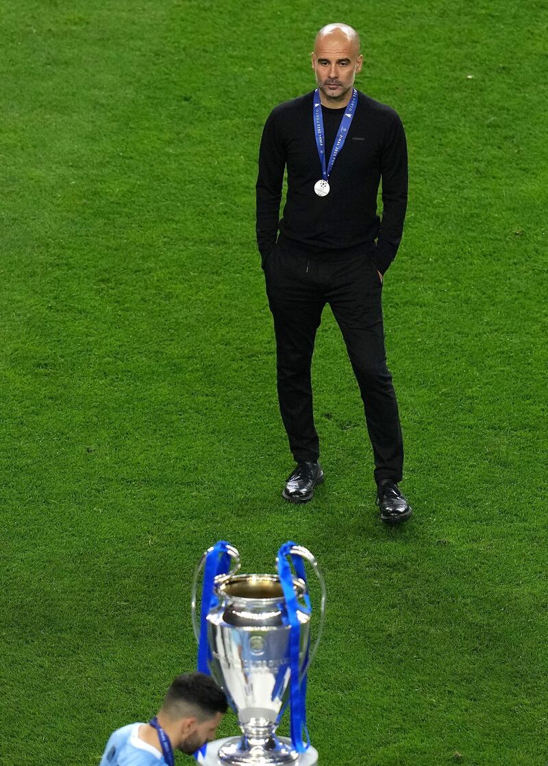 Pep Guardiola looks at the trophy after the final whistle. PA