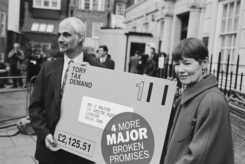 Then Labour Shadow Chief Secretary to the Treasury Mr Darling and MP Glenda Jackson hold an oversized tax bill for Prime Minister John Major during a demonstration outside Conservative Party Central Office in London in 1997