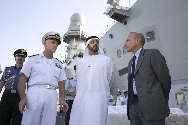 Sheikh Abdullah bin Zayed, Minister of Foreign Affairs, is shown around the Italian aircraft carrier, The Cavour, yesterday by Giorgio Starace, right, the Italian ambassador to the UAE, and Admiral Paolo Treu, the commander of the Italian naval group, while it is docked in Mina Zayed in Abu Dhabi. Silvia Razgova / The National