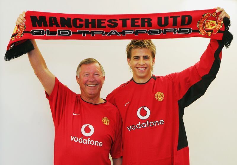 Gerard Pique poses with Sir Alex Ferguson of Manchester United while holding a United scarf after signing for Manchester United on July 1, 2004 at Carrington Training Ground in Manchester, England. Getty Images