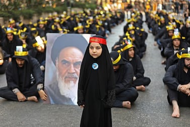 Supporters of the Lebanese Shiite Hezbollah movement hold a picture of Iran's late supreme leader Ayatollah Ruhollah Khomeini, as they take part in a religious mourning procession on the tenth day of the lunar month of Muharram, which marks the day of Ashura, in a suburb of the capital Beirut. AFP