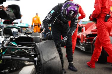 Lewis Hamilton inspects his battered tyre after winning the British Grand Prix at Silverstone. Reuters