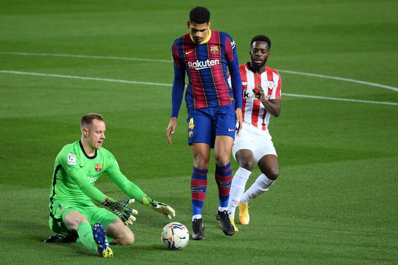 Athletic Bilbao's Spanish forward Inaki Williams (R) challenges Barcelona's Uruguayan defender Ronald Araujo in front of Barcelona's German goalkeeper Marc-Andre ter Stegen during the Spanish league football match FC Barcelona against Athletic Club Bilbao at the Camp Nou stadium in Barcelona on January 31, 2021. (Photo by LLUIS GENE / AFP)