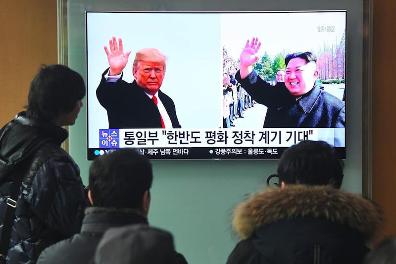 People watch a television news report showing pictures of US President Donald Trump (L) and North Korean leader Kim Jong Un at a railway station in Seoul on March 9, 2018. 
US President Donald Trump agreed on March 8 to a historic first meeting with North Korean leader Kim Jong Un in a stunning development in America's high-stakes nuclear standoff with North Korea. / AFP PHOTO / Jung Yeon-je