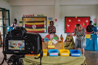 Kat Tucker (2nd R), the founder of Clarke Junior School, is seen filming a new TV show which is aimed for children to learn at home with their families as schools remained closed during the COVID-19 coronavirus lockdown in Kampala, Uganda, on April 16, 2020.  Ugandan President Yoweri Museveni on April 14, 2020, ordered the extension of a 21-day nationwide lockdown in a bid to halt the spread of the COVID-19 coronavirus. / AFP / SUMY SADURNI
