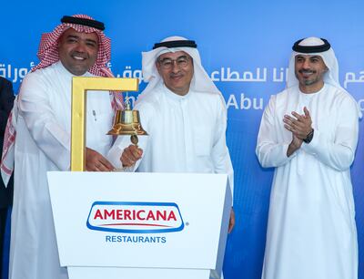 Chairman of Americana Restaurants, Mohamed Alabbar, centre, with vice chairman Abdulmalik Al Hogail, ring the bell at the Abu Dhabi Securities Exchange. Victor Besa / The National