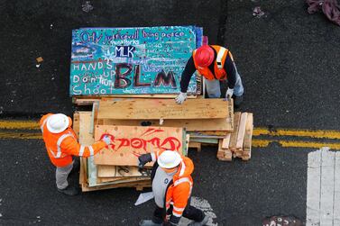 City crews work to dismantle plywood with art drawn on as Seattle Police retake the Capitol Hill Occupied Protest area. Reuters