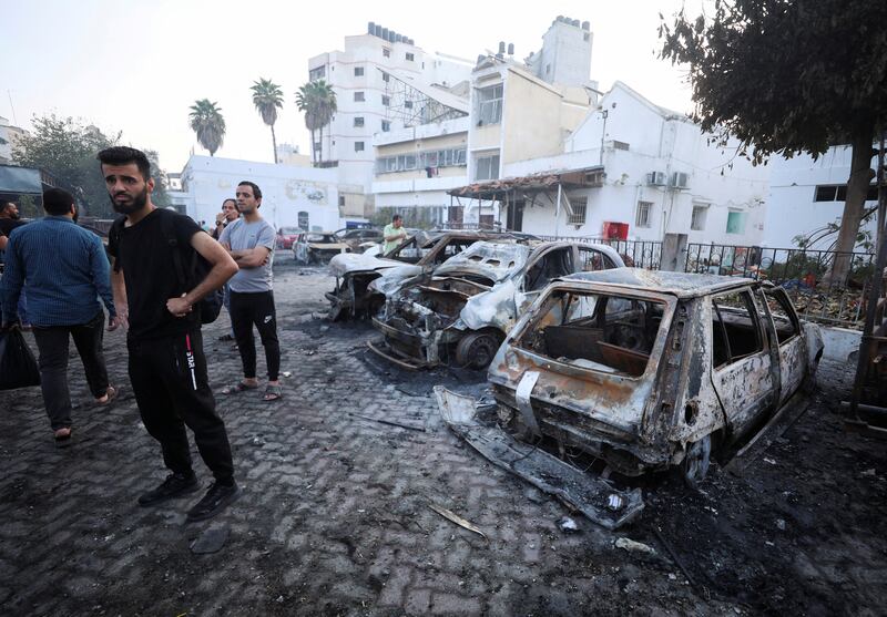 People inspect the area around Al Ahli Arab Hospital, where hundreds of Palestinians were killed in a blast that Israeli and Palestinian officials blamed on each other. Reuters