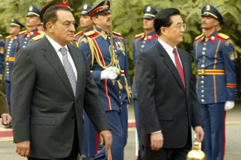 Egyptian President Hosni Mubarak (L) walks with his Chinese counterpart Hu Jintao during the traditional honor guard review upon the latter's arrival at the presidential palace in Cairo, 29 January 2004. Jintao is on an official four-day visit to Egypt and his activities will focus on economic ties as well as reviewing political developments in the Middle East. Mubarak signed in 1999 a "strategic partnership" accord with China, an agreement which will be reviewed during Jintao's talks in Egypt to take account of regional changes.   AFP PHOTO/Cris BOURONCLE