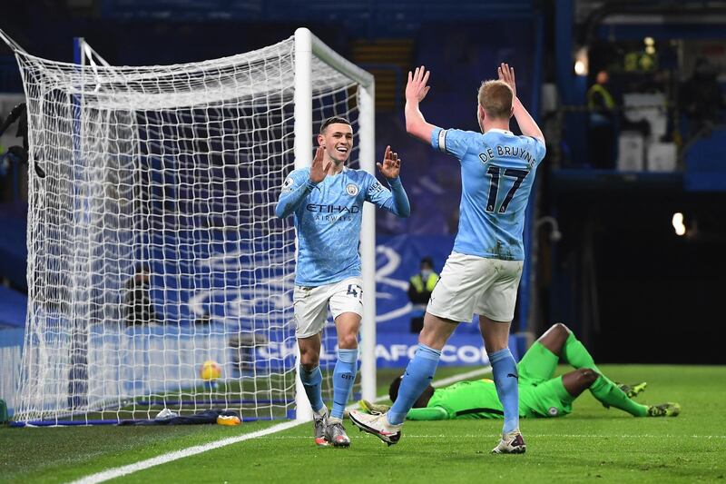 LONDON, ENGLAND - JANUARY 03: Phil Foden (l) of Manchester City celebrates with team mate Kevin De Bruyne (r) after scoring their sides second goal during the Premier League match between Chelsea and Manchester City at Stamford Bridge on January 03, 2021 in London, England. The match will be played without fans, behind closed doors as a Covid-19 precaution. (Photo by Andy Rain - Pool/Getty Images)