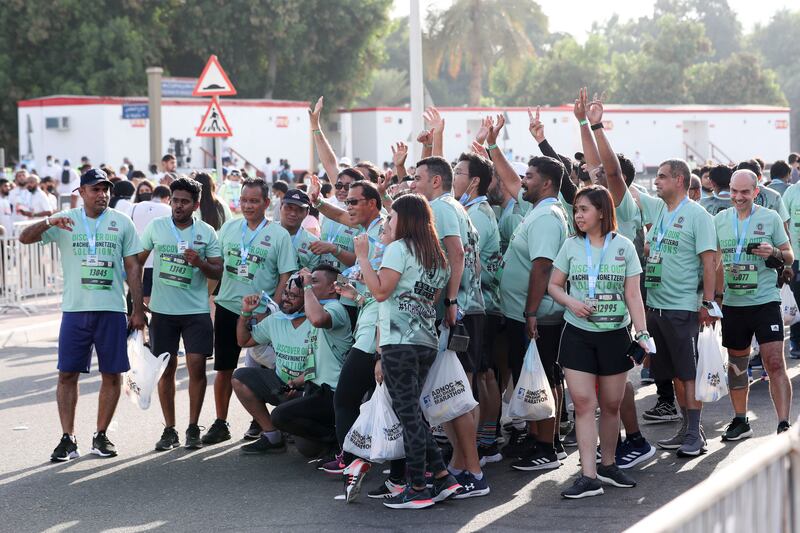 Participants take photos after completing their run at the Abu Dhabi Marathon.